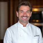 Portrait souriant de Marc Dubois, chef pâtissier expert.